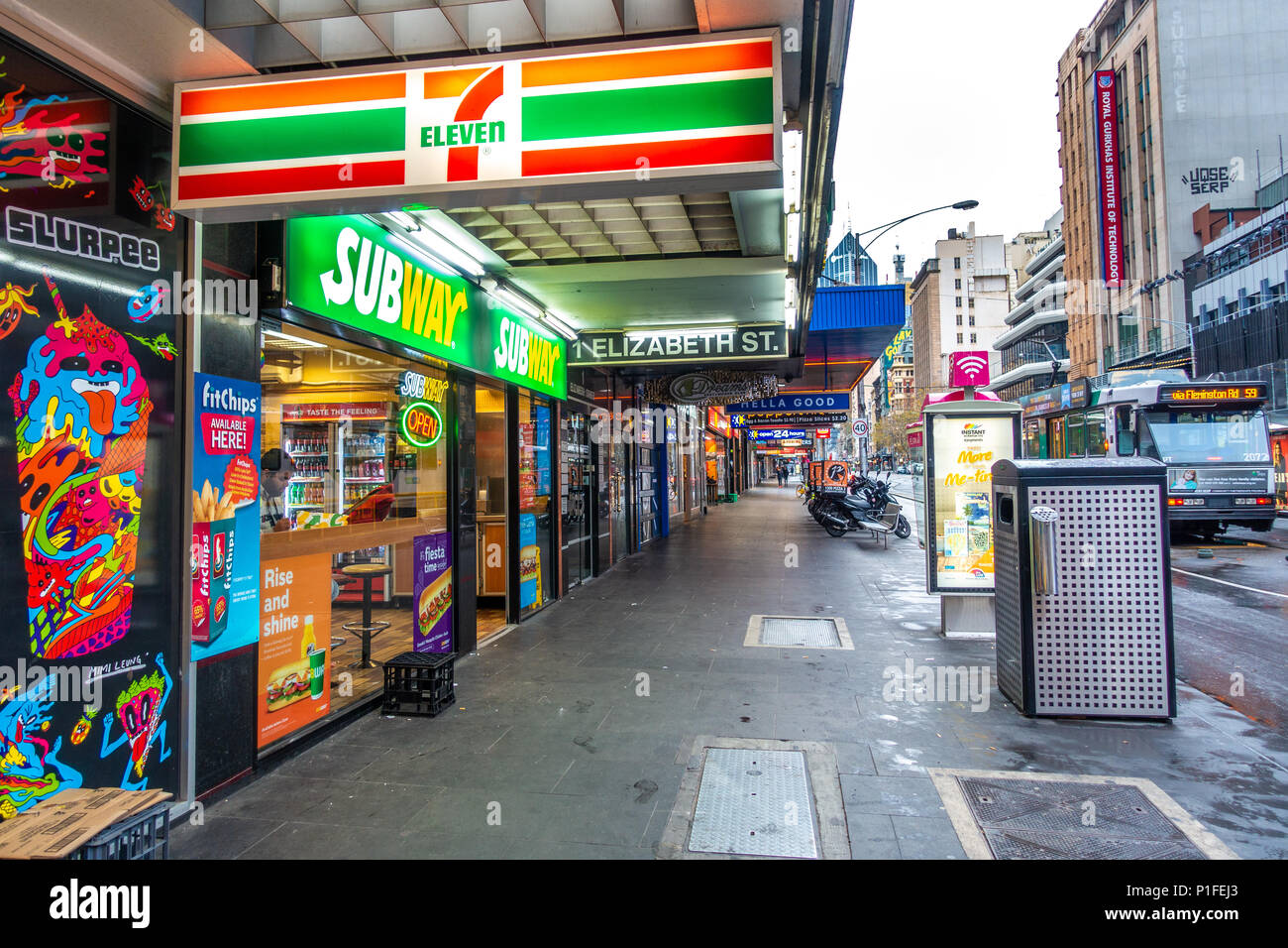 Pedestrian sidewalk lined with shops near tram stop in Melbourne's CBD. VIC Australia. Stock Photo
