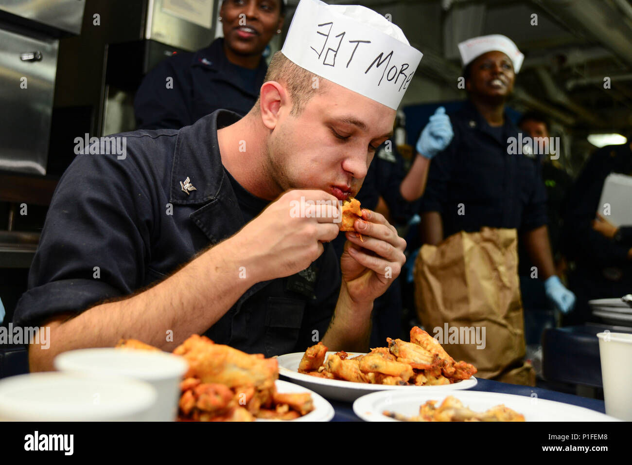 161025-N-GN619-110 ATLANTIC OCEAN (Oct. 24, 2016) Petty Officer 3rd Class Jason Goodpaster, from Lawrenceburg, Kentucky, eats chicken wings during a Wing Eating Contest held on the mess decks of the aircraft carrier USS George Washington (CVN 73). George Washington, homeported in Norfolk, is currently underway conducting carrier qualifications in the Atlantic Ocean. (U.S. Navy photo by Petty Officer 2nd Class Kris R. Lindstrom) Stock Photo