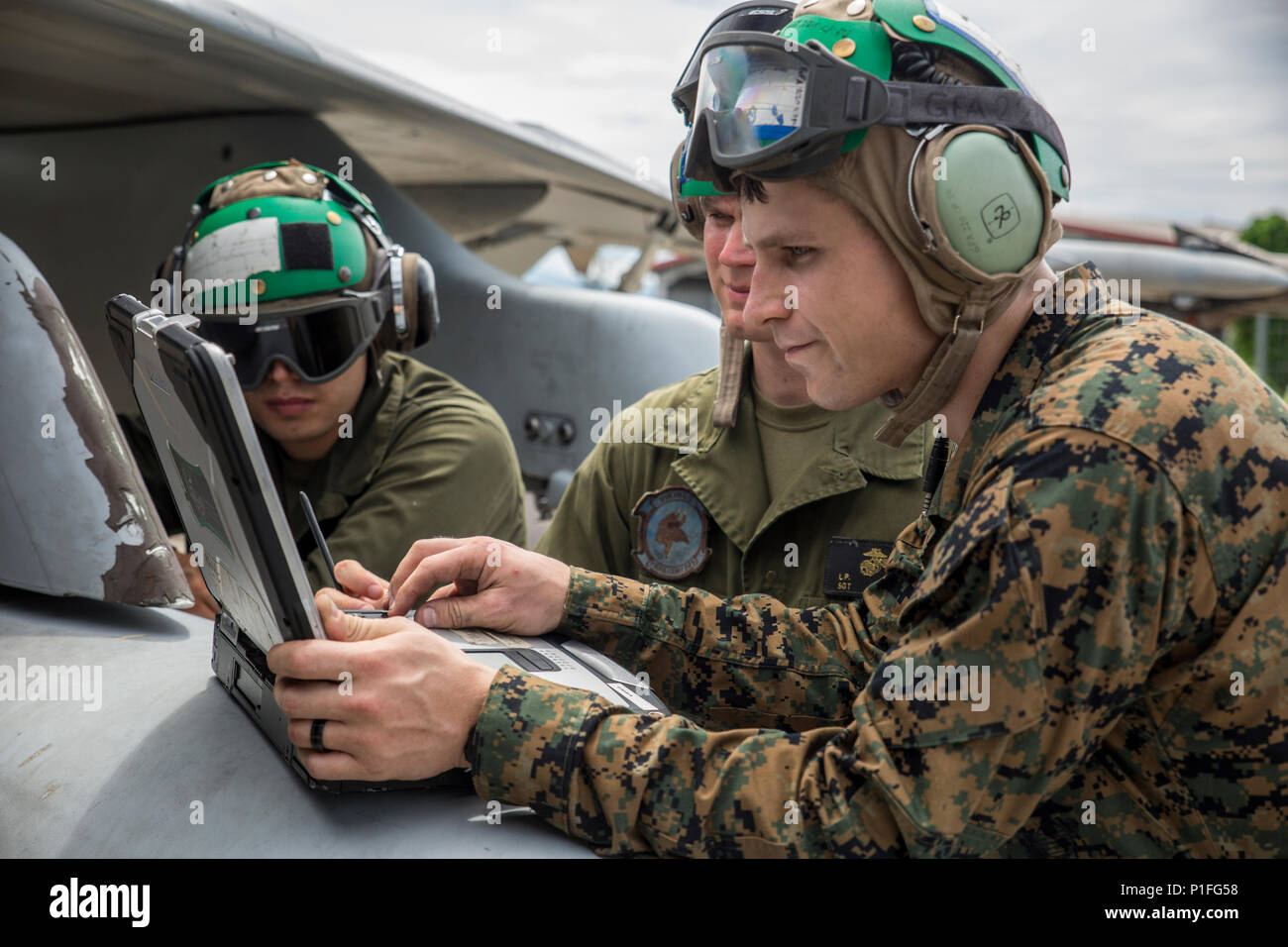 U.S. Marine Corps Cpl. Steven Benson, right, Sgt. Lee Elvik, middle, and Lance Cpl. Forest Kenworthy II, airframers with Marine All-Weather Fighter Attack Squadron (VMFA (AW)) 225, troubleshoot an F/A-18D Hornet at Sam Ratulangi International Airport, Indonesia, Oct. 31, 2016. VMFA (AW) 225 is participating in exercise Cope West 17, the first fighter-focused exercise in 19 years involving the U.S. Marine Corps and Indonesian Air Force. The squadron plans to complete their unit air-to-air training requirements, which focuses on basic fighter maneuvering, section engaged maneuvering, offensive a Stock Photo