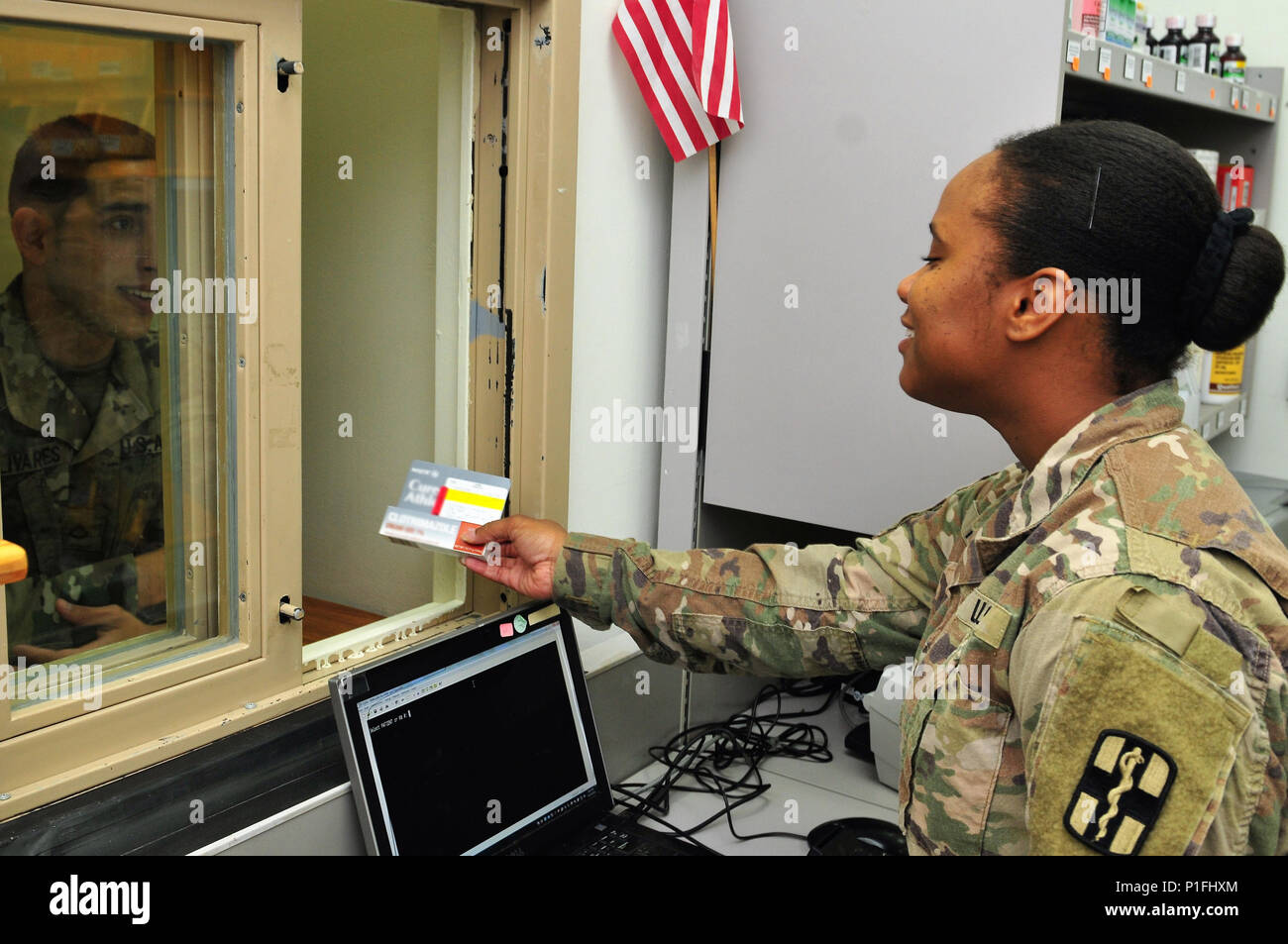 Sgt. Jessica Evans, pharmacy specialist with the 31st Combat Support Hospital and Clewiston, Fla. native, hands out a perscription to a Soldier Oct. 25, 2016 at Camp Arifjan, Kuwait. Evans along with a small team of Soldiers operate the 31st CSH pharmacy providing pharmaceutical support to patients suffering from injuries and illnesses throughout the ARCENT area of operations. The team processes more than 3,500 outpatient prescriptions a month to service members and civilians while providing support to inpatient care and other facilities throughout the region. (U.S. Army photo by Sgt. Aaron El Stock Photo