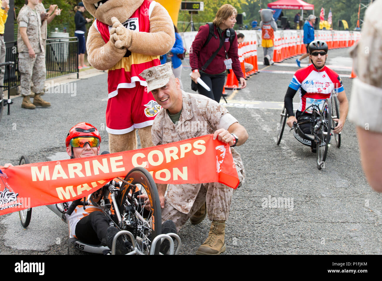 U.S Marine Corps Col. Joseph M. Murray, commander of Marine Corps Base Quantico, poses with Arkadiusz Skrzypinski of New York, NY, 1st place handcrank winner of the 41st Marine Corps Marathon, at the finish line near the Marine Corps War Memorial in Arlington, Va., Oct. 30, 2016. Also known as 'The People's Marathon,' the 26.2 mile race drew roughly 30,000 participants to promote physical fitness, generate goodwill in the community, and showcase the organizational skills of the Marine Corps. (U.S. Marine Corps photo by Staff Sgt. Sarah R. Hickory) Stock Photo