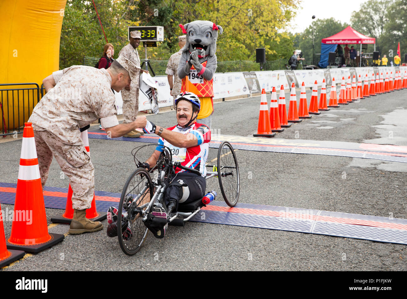 U.S Marine Corps Col. Joseph M. Murray, commander of Marine Corps Base Quantico, fist bumps Rick Weisbrod, New York, NY, handcrank participant of the 41st Marine Corps Marathon, at the finish line near the Marine Corps War Memorial in Arlington, Va., Oct. 30, 2016. Also known as 'The People's Marathon,' the 26.2 mile race drew roughly 30,000 participants to promote physical fitness, generate goodwill in the community, and showcase the organizational skills of the Marine Corps. (U.S. Marine Corps photo by Staff Sgt. Sarah R. Hickory) Stock Photo
