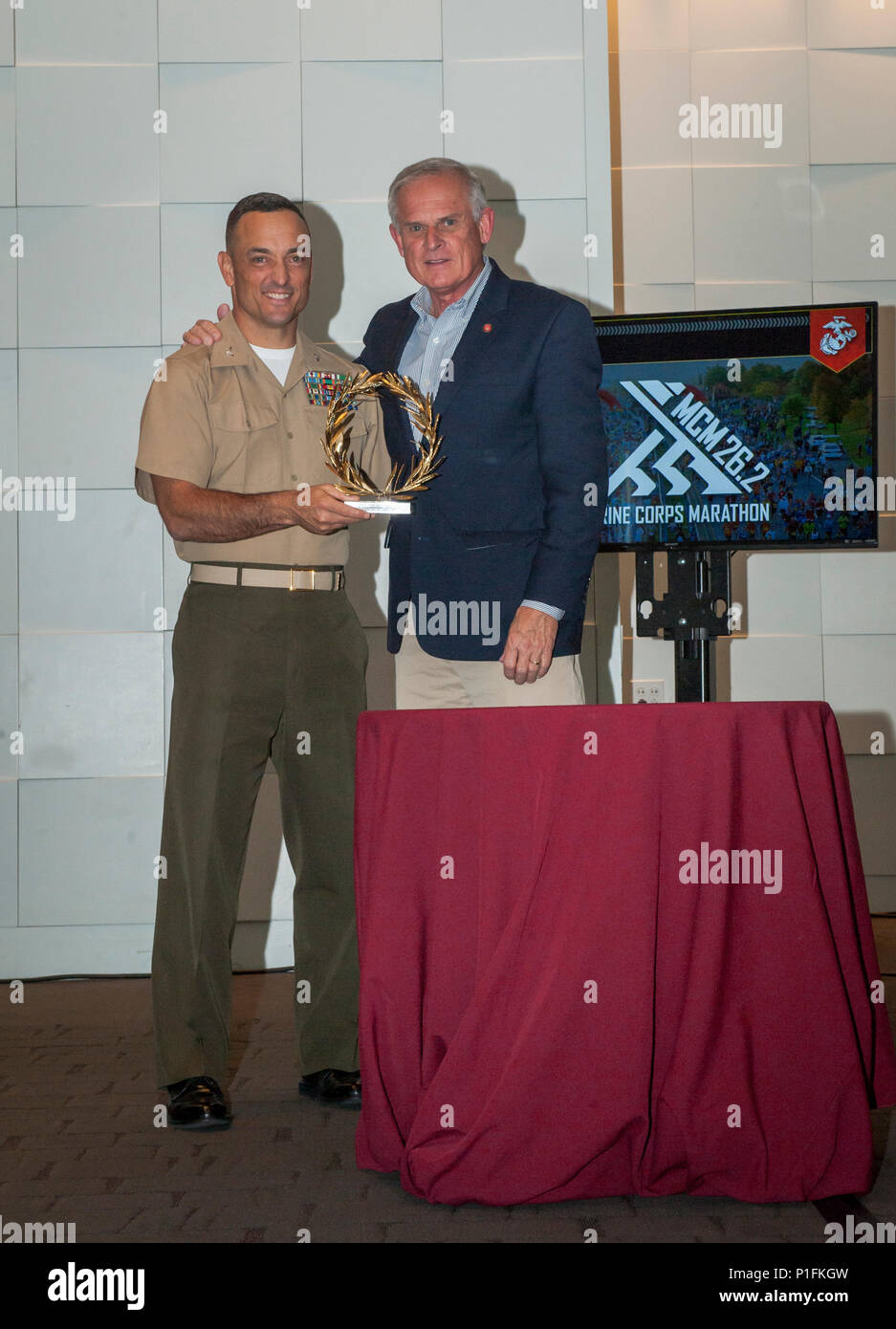 U.S. Marine Corps Col. Joseph Murray, commanding officer of Marine Corps Base Quantico, holds a golden laurel which will be presented at the awards ceremony to the top female and male finishers of the 41st Marine Corps Marathon (MCM), with Timothy Kilduff, executive director of the 41st MCM at the Wolfgang Puck Catering and Events Center at National Harbor, Md., Oct. 28, 2016. Also known as 'The People's Marathon,' the 26.2 mile race drew roughly 30,000 participants to promote physical fitness, generate goodwill in the community, and showcase the organizational skills of the Marine Corps. (U.S Stock Photo