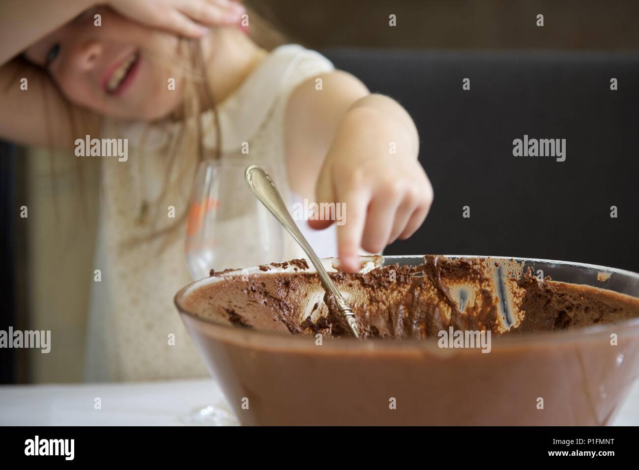 Chocolate: the temptation of a large bowl of chocolate mousse proves irresistible to a young girl Stock Photo