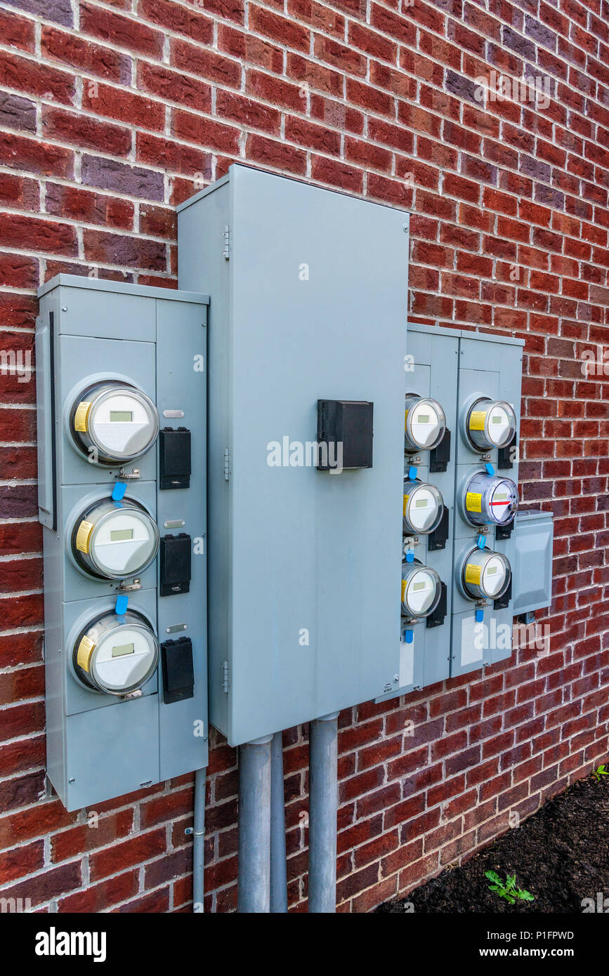 Vertical shot of apartment electric meters attached to the external ...