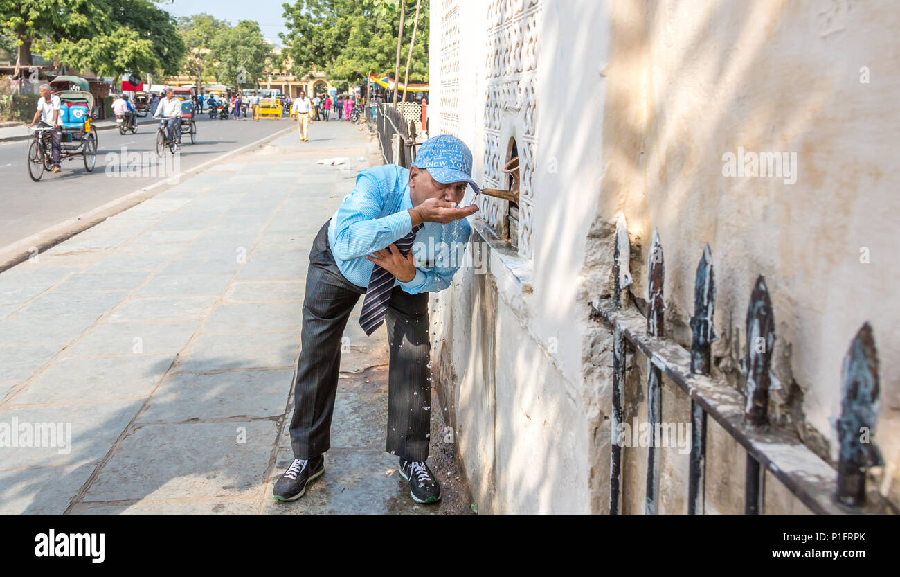 Man drinking clean, potable water from a water station in Jaipur city, India. Stock Photo