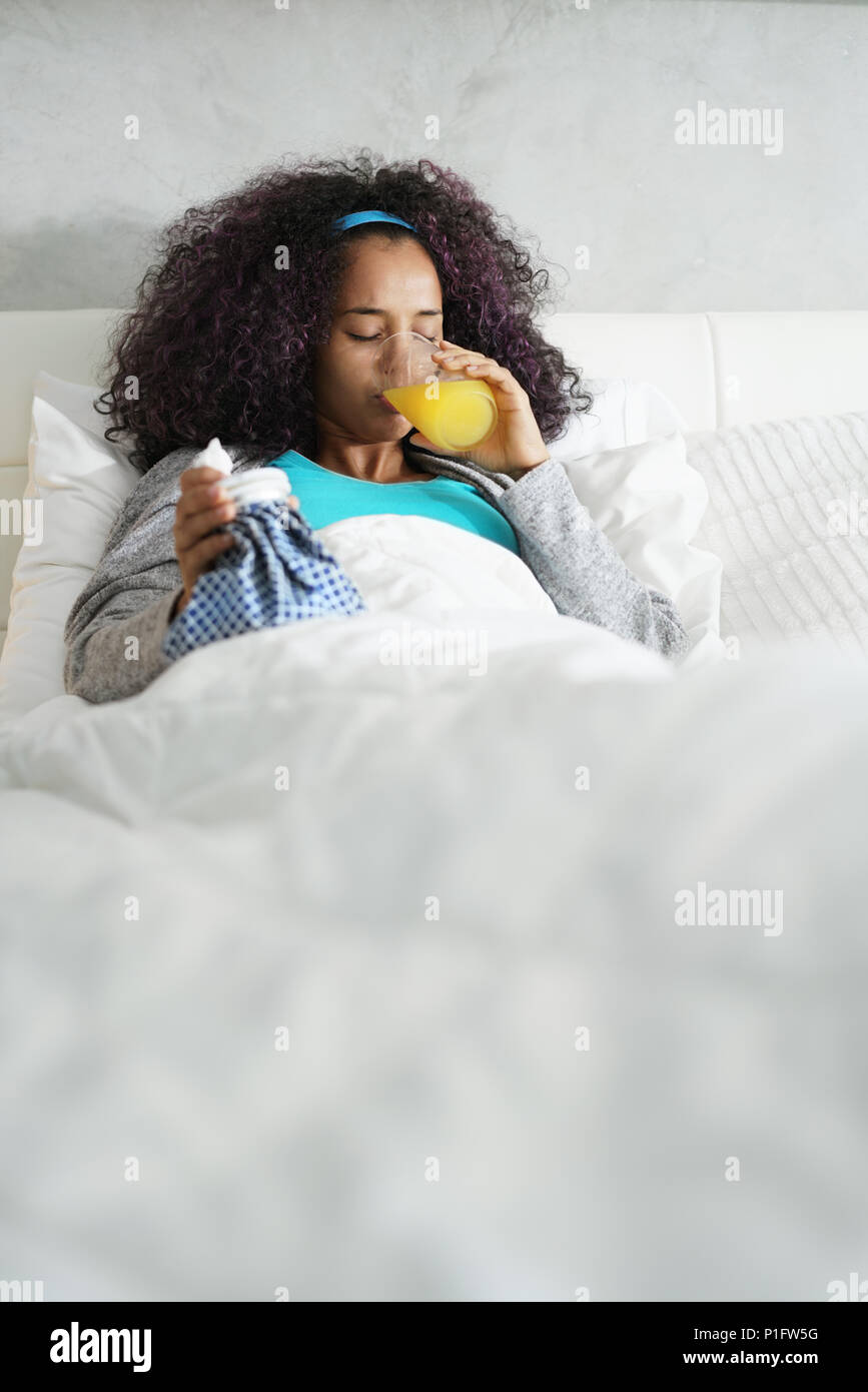 Black Woman With Flu And Cold Holding Ice Bag Stock Photo