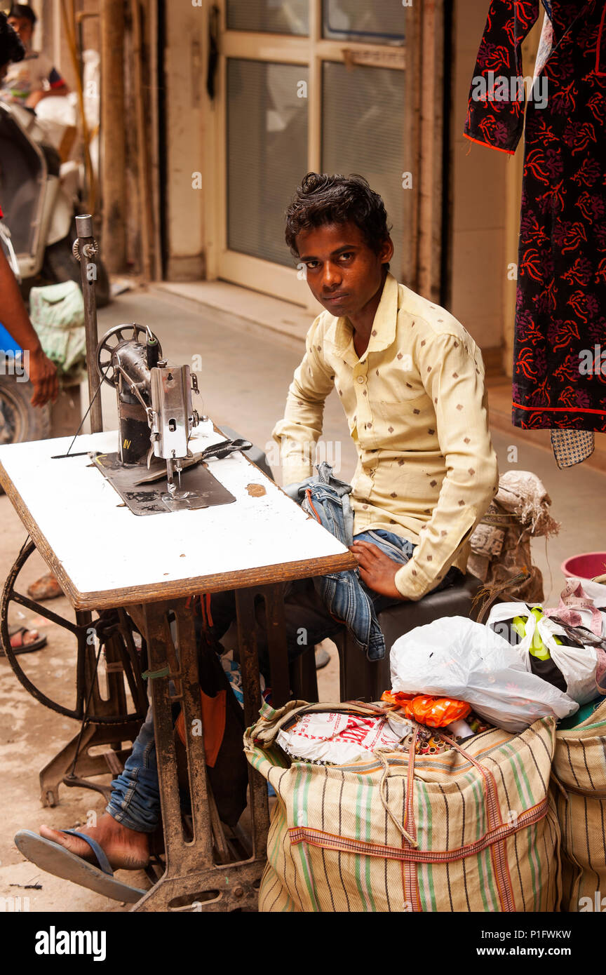 Young boy working in his sewing machine on the street at Sangatrashan, New Delhi, India Stock Photo