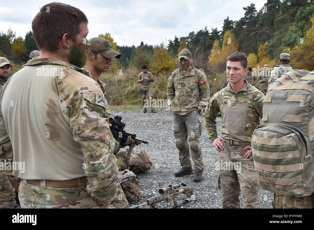 Soldiers from the United Kingdom, Denmark and the United States have a conversation before they start the Rough Terrain Run task during the European Best Sniper Squad Competition at the 7th Army Training Command’s, Grafenwoehr Training Area, Bavaria, Germany, Oct. 26, 2016. The European Best Sniper Squad Competition is an Army Europe competition challenging militaries from across Europe to compete and enhance teamwork with Allies and partner nations. (U.S. Army photo by Visual Information Specialist Gertrud Zach) Stock Photo