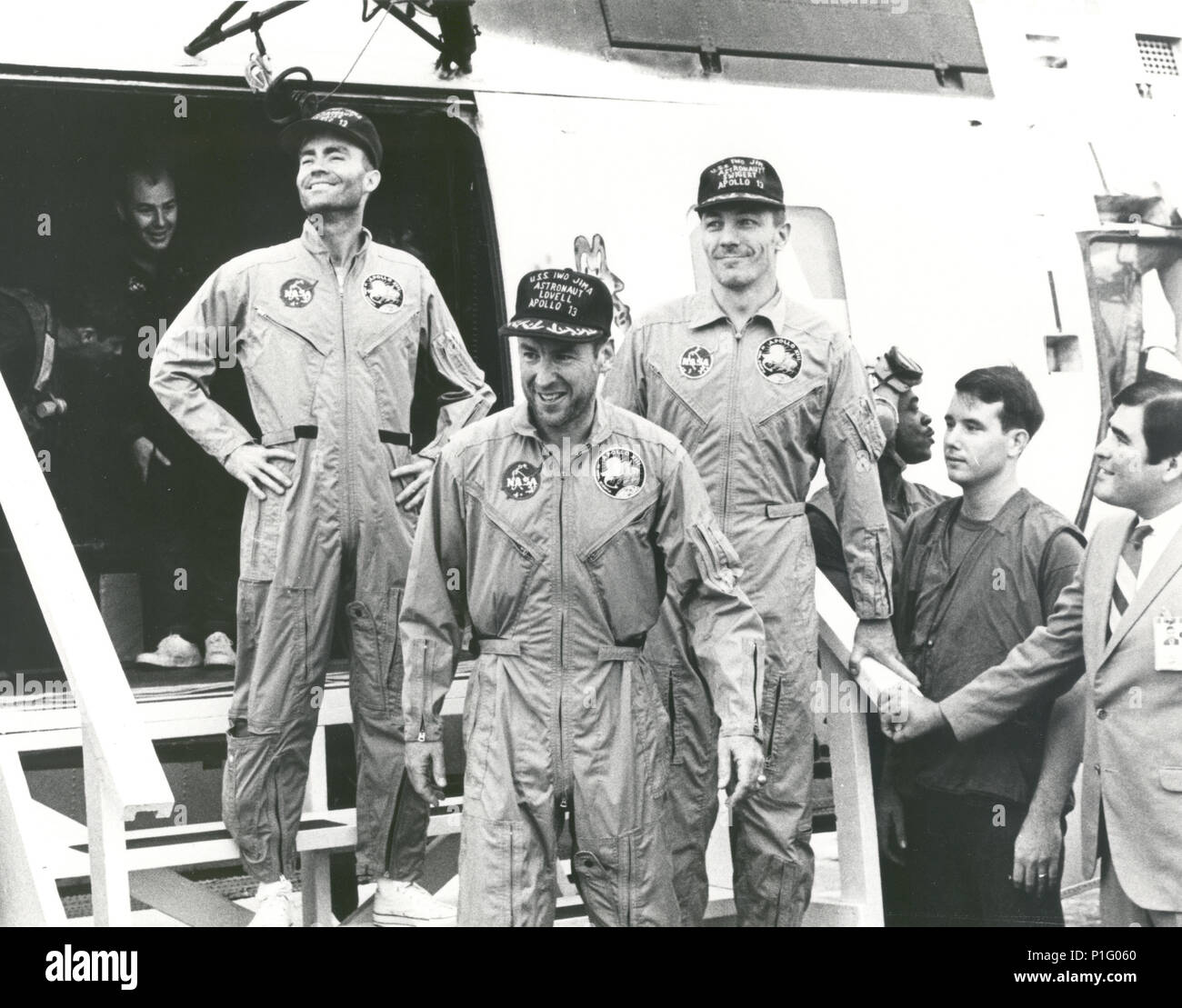 The crew of the Apollo 13 mission step aboard the U.S.S. Iwo Jima, prime recovery ship for the mission, following splashdown and recovery operations in the South Pacific. Exiting the helicopter (from left) astronauts Fred. W. Haise, Jr., lunar module pilot; James A. Lovell Jr., commander; and John L. Swigert Jr., command module pilot. The Apollo 13 spacecraft splashed down at 12:07:44 pm CST on April 17, 1970. Stock Photo
