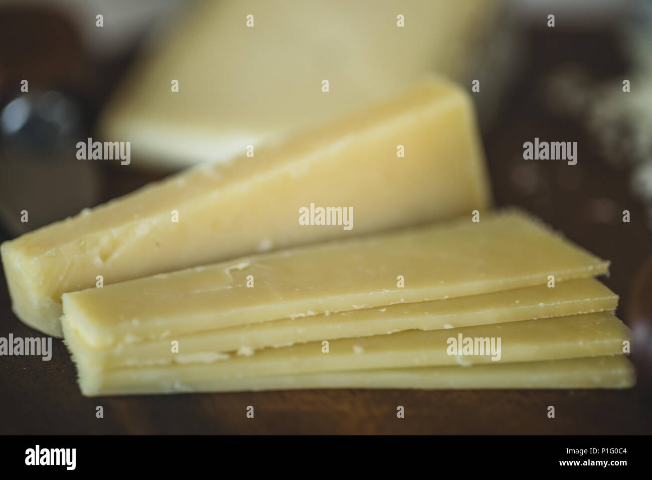 closeup of sliced white cheddar on cheese plate Stock Photo