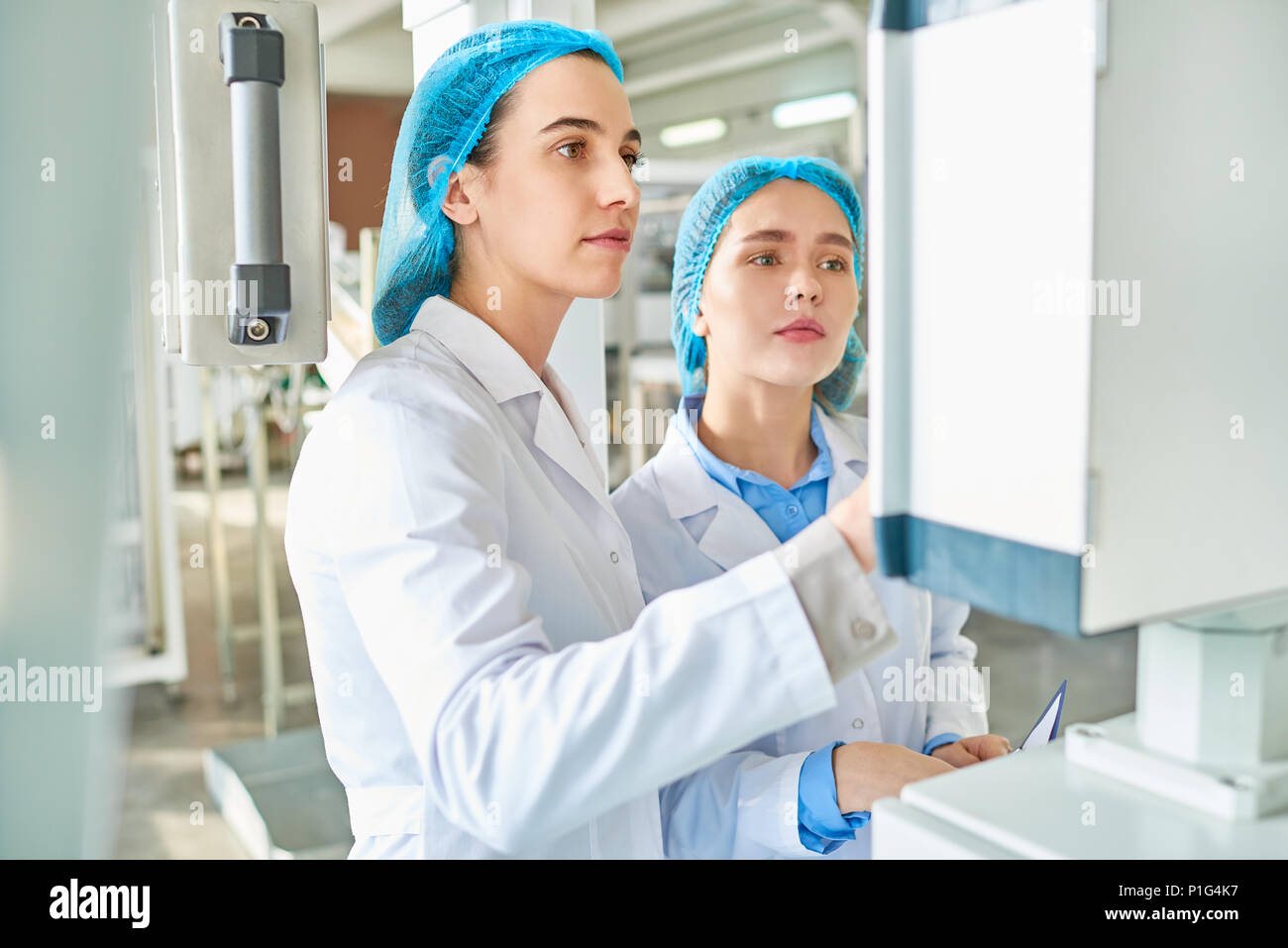 Two Young Women Working at Factory Stock Photo