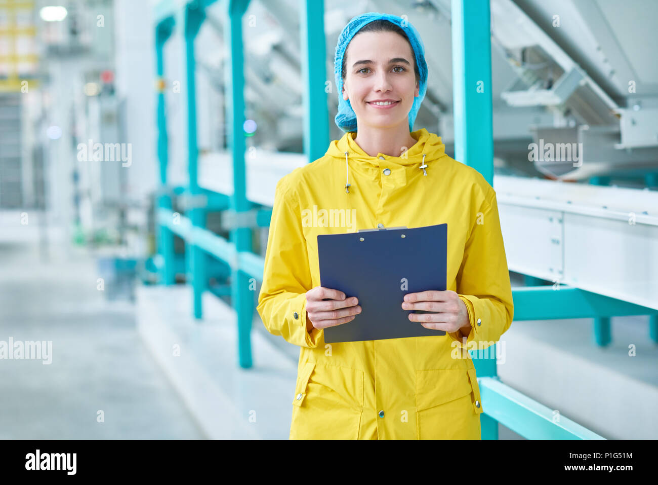 Cheerful Young Woman at Factory Stock Photo