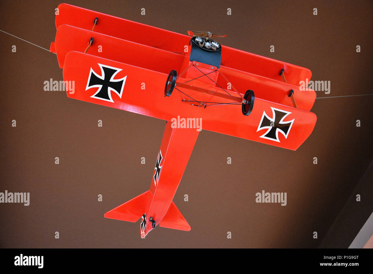 Red model of German plane from World War one, also called Great War. Model plane with double wings and two iron crosses. Airplane model double winged. Stock Photo