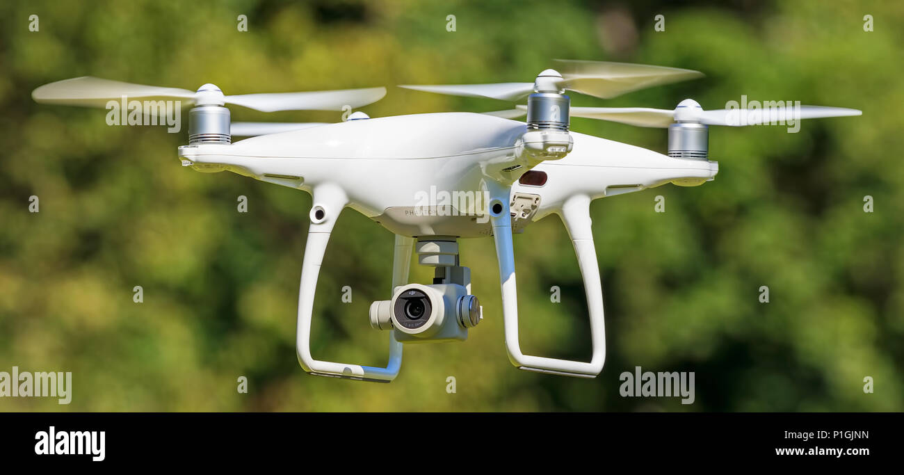 DJI Phantom 4 Pro drone in flight, green trees in the background, selective  focus on the drone Stock Photo - Alamy