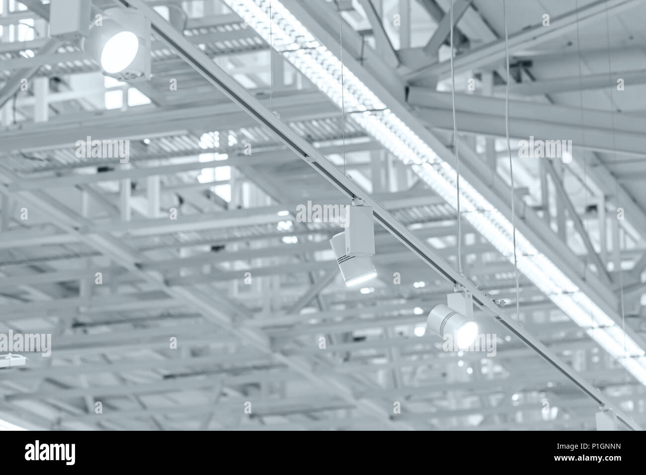 row of bright halogen spotlights on exhibition ceiling. industrial building interior Stock Photo