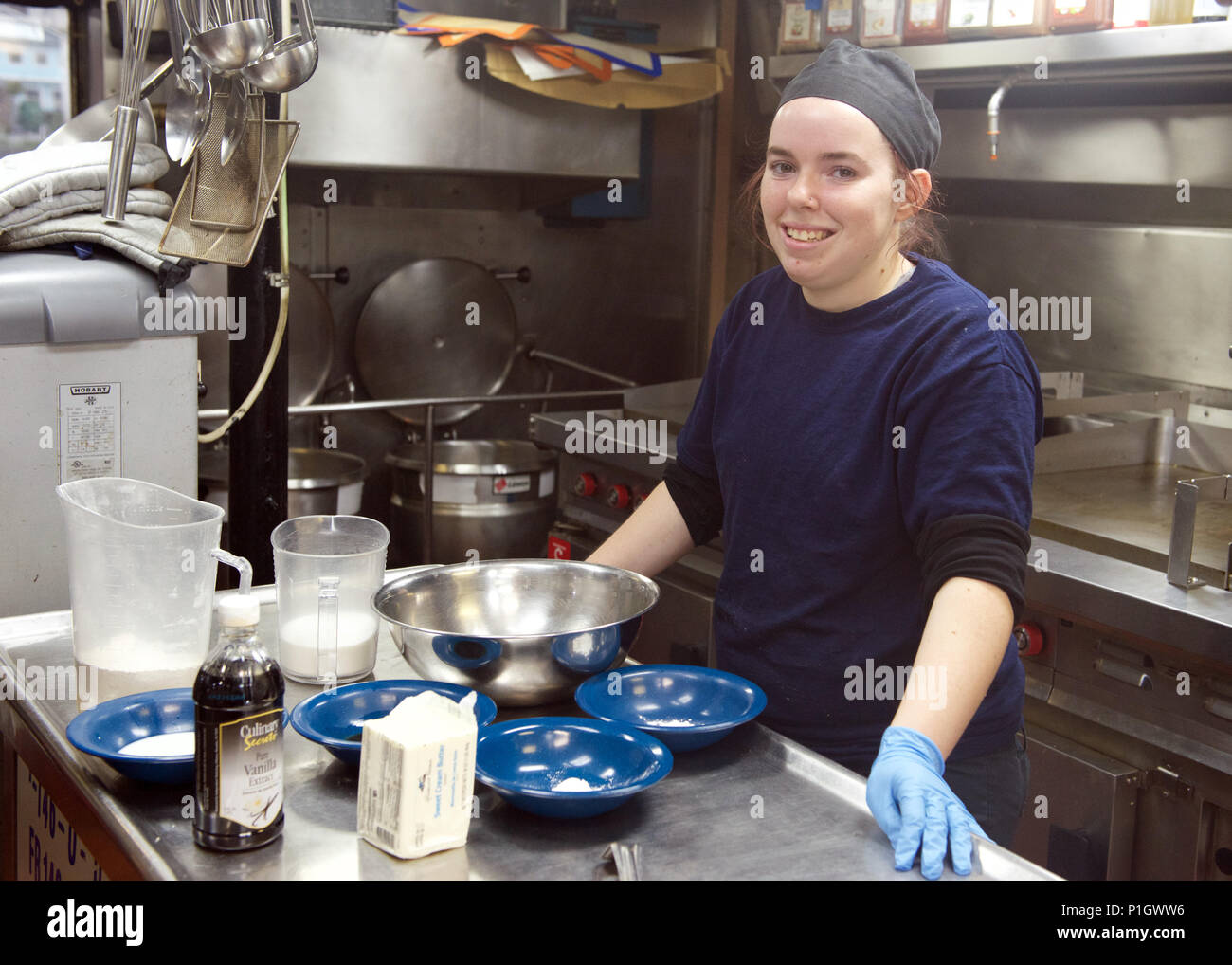 Mandy Lynn, a student at the Tongue Point Job Corps center in Astoria, Ore., works in the galley of the Coast Guard Cutter Steadfast also homeported in Astoria, Oct. 13, 2016. As part of her education, Mandy is working with Coast Guard cooks to learn different culinary techniques and styles. U.S. Coast Guard photo by Petty Officer 3rd Class Jonathan Klingenberg. Stock Photo