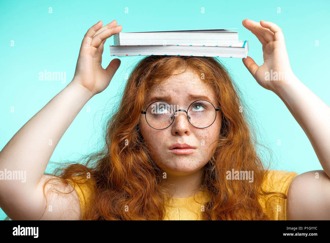 Schoolgirl carrying her books on her head hi-res stock photography and ...