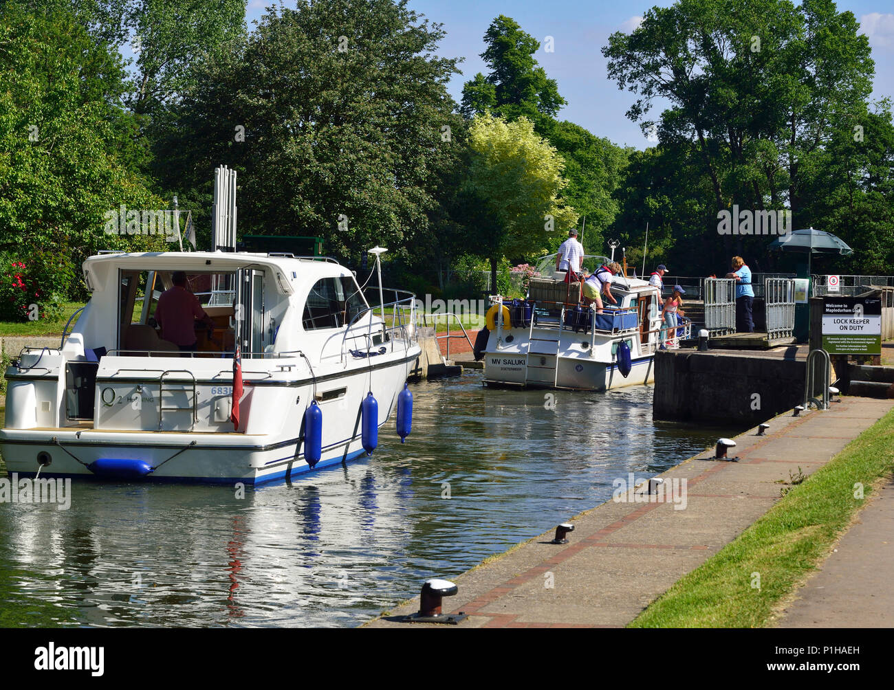 Pleasure boats entering Mapledurham Lock on the upper Thames reach Purley-On-Thames in Berkshire, England Stock Photo