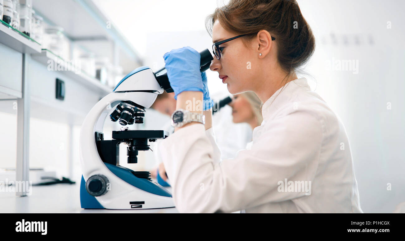 Young scientist looking through microscope in laboratory Stock Photo ...