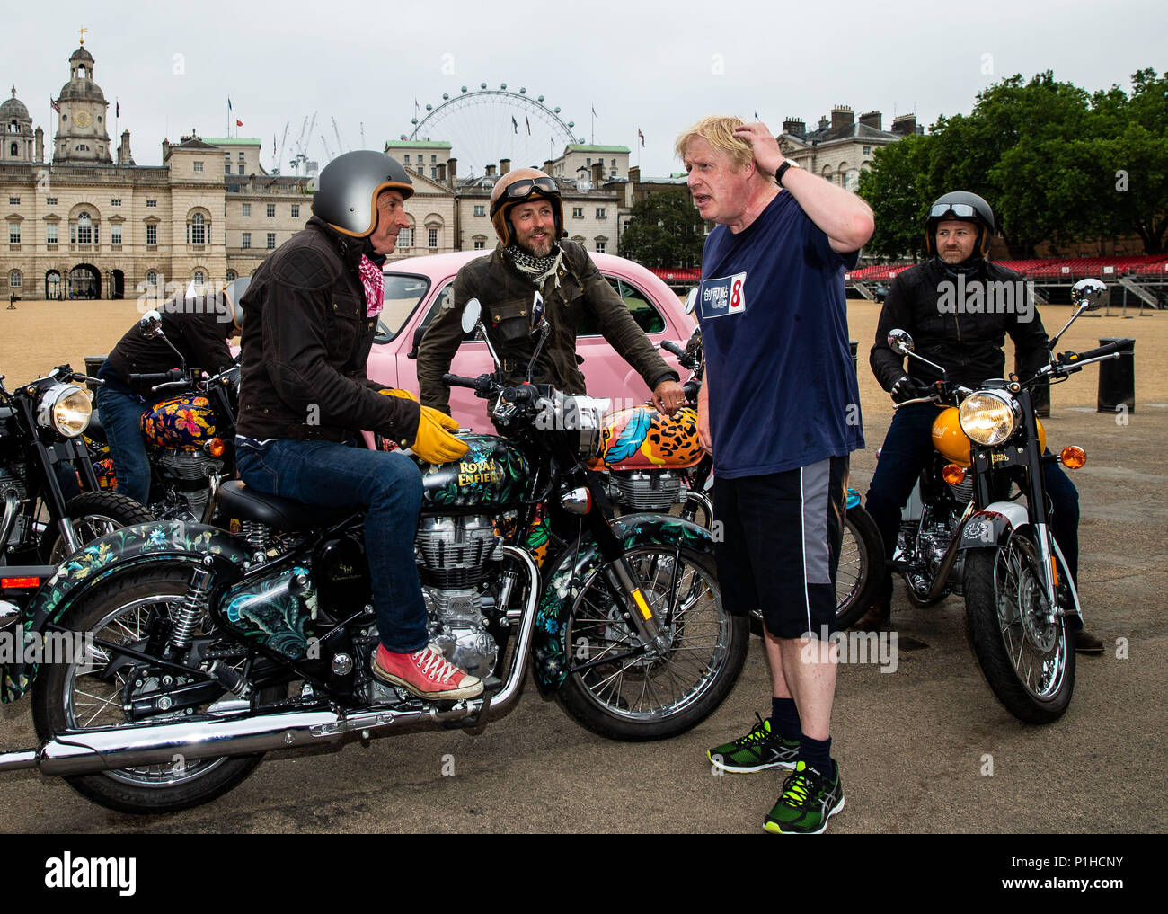 Boris Johnson, Secretary of State for Foreign Affairs chats to Simon de Burton on the House of Hackney bike and Sam Pelly on the Boyarde bike while on Elephant Family's â€˜Concours d'elephant' outside Horse Guards during the photocall in London. PRESS ASSOCIATION Photo. Picture date: Tuesday June 12, 2018. A customised fleet of 12 Ambassador cars, eight Royal Enfield motorbikes, a tuk tuk and a Gujarati Chagda made up the â€˜Concours d'elephant' - a cavalcade of designer inspired, quintessentially Indian vehicles - while thirty beautifully decorated elephant sculptures will stand senti Stock Photo