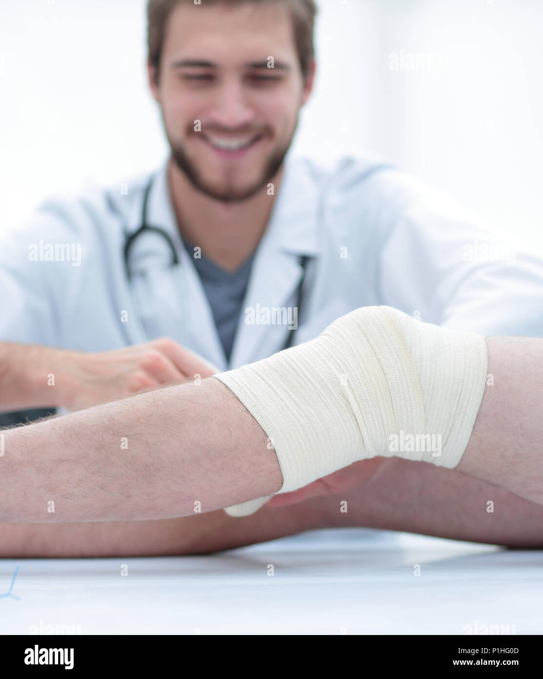 doctor bandaging a wound on the leg of the patient Stock Photo Alamy