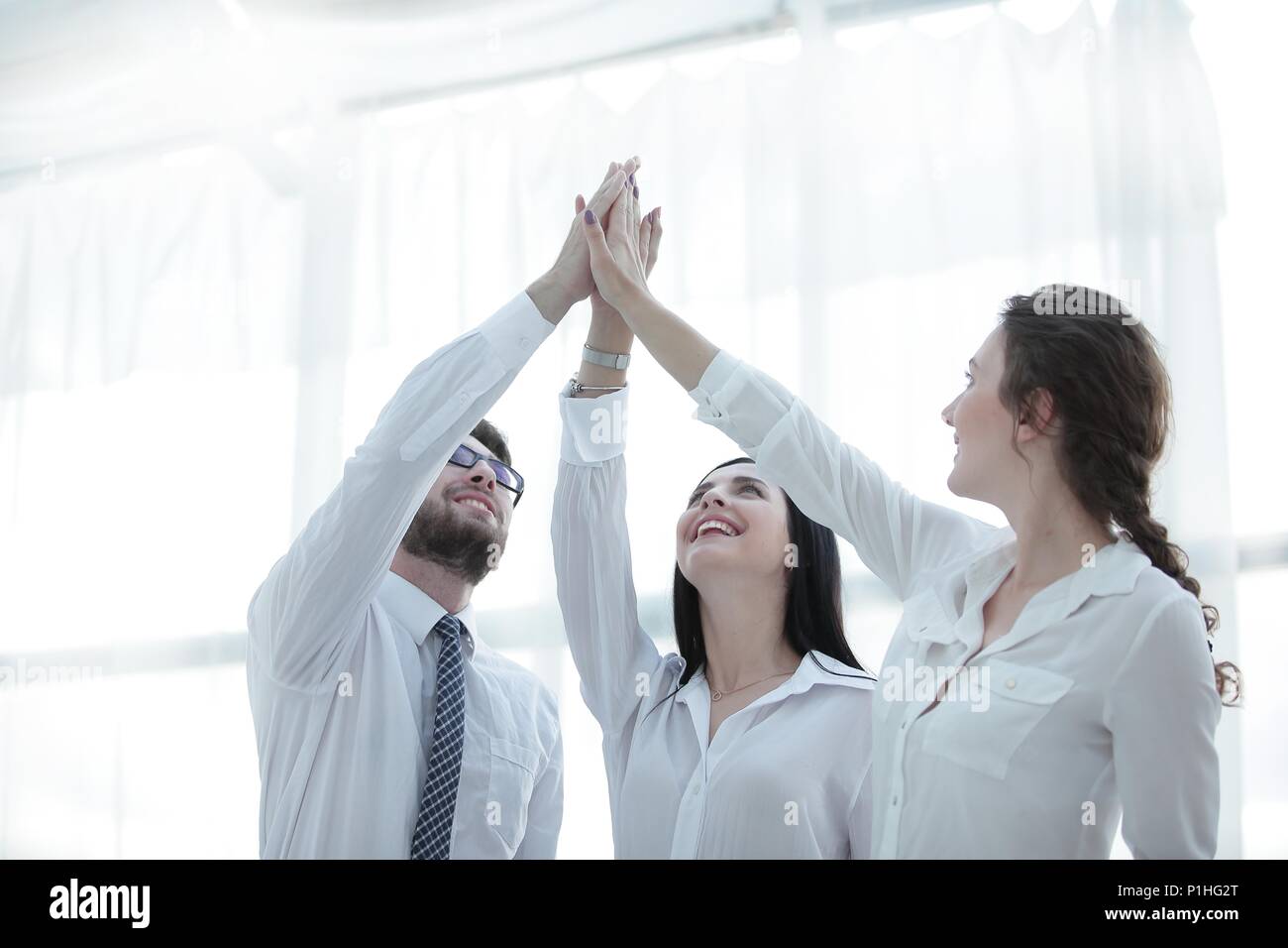 successful business team giving each other a high five Stock Photo - Alamy