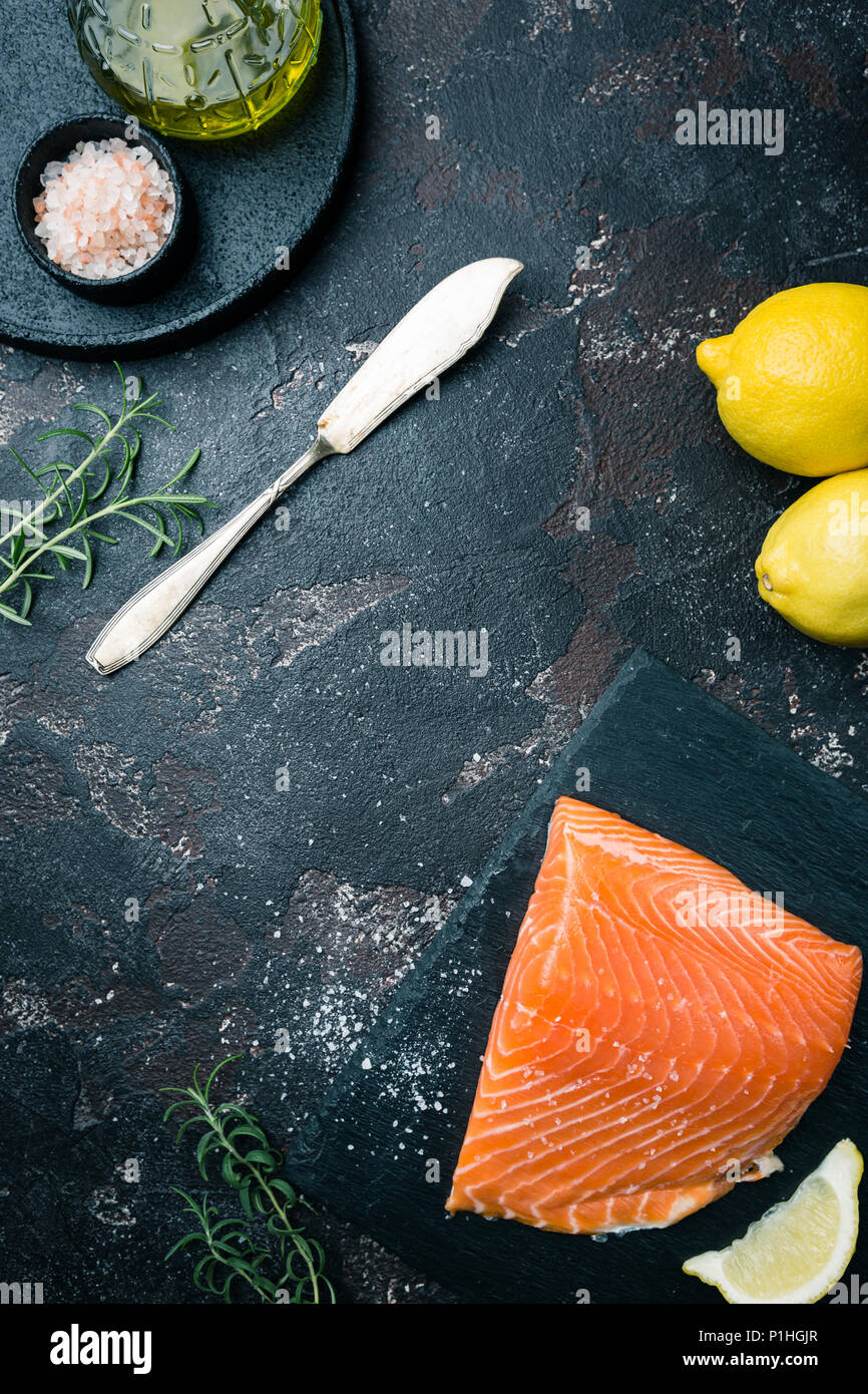Fresh raw salmon fillet on dark stone background, top view with copy ...