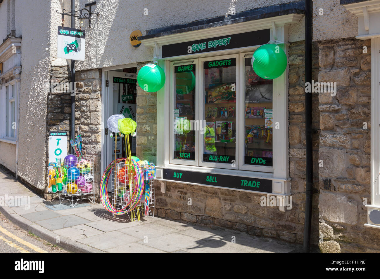 An attractive toy shop with outside colourful displays of hoops and balls, just off the Market Square, Malmesbury, Wiltshire, UK Stock Photo