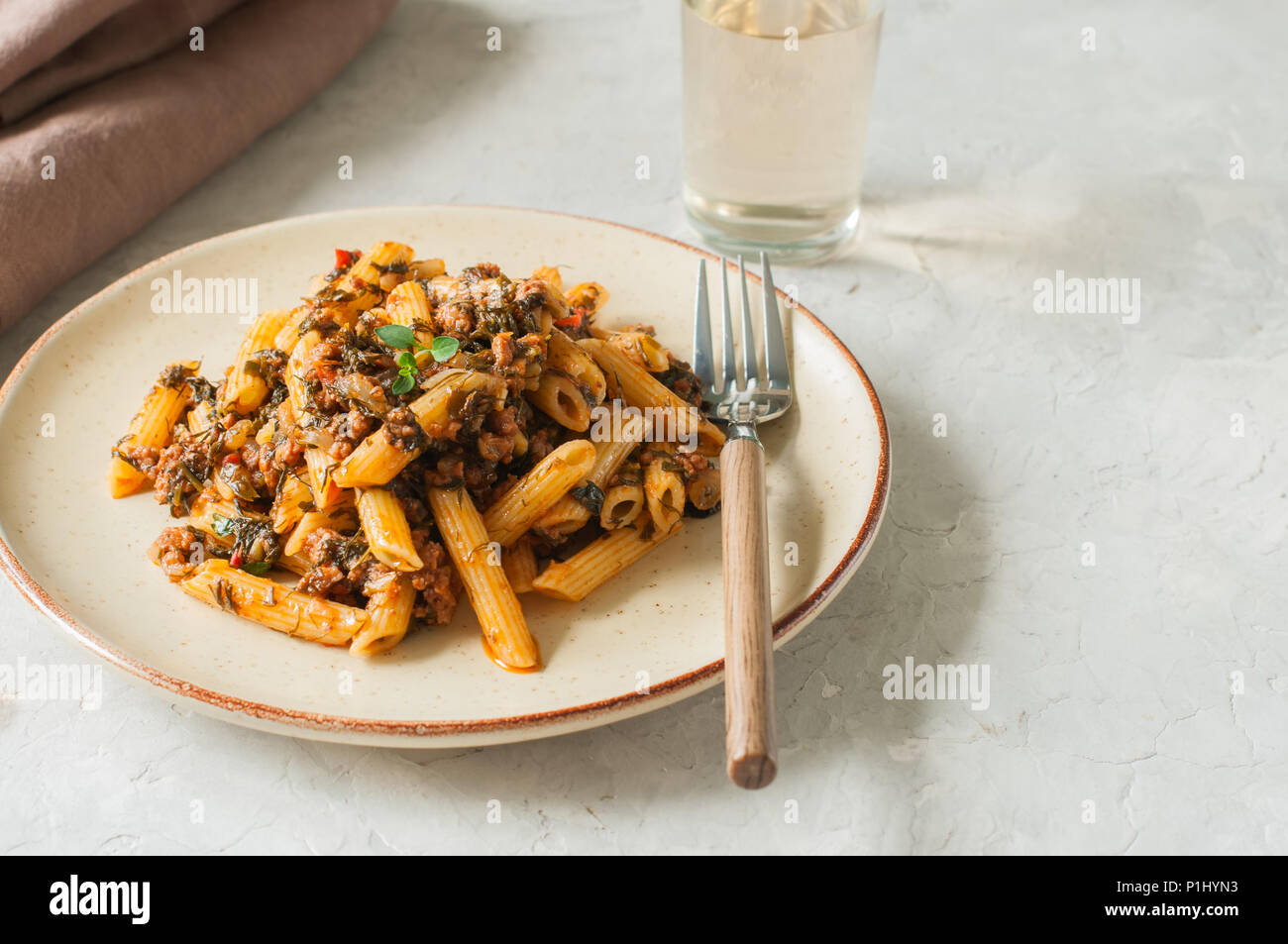 Tomato sauce ground beef pasta on a white stone background. Toned Stock