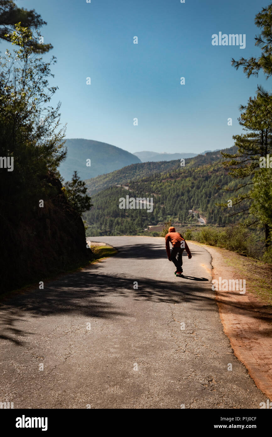 Downhill skate boarding on the swift roads of Paro Bhutan Stock Photo