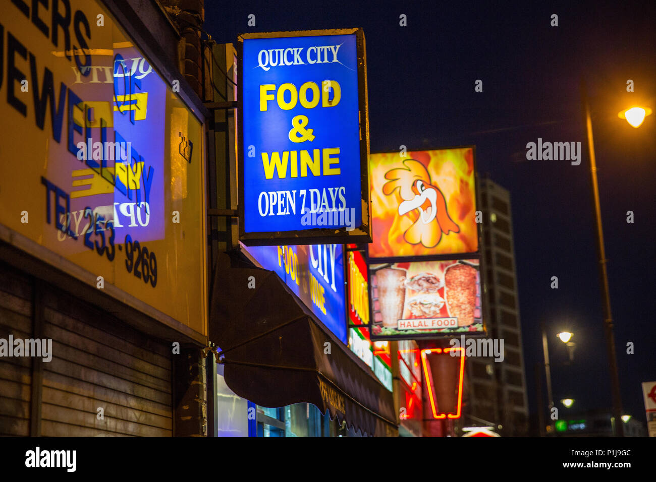Fast food outlet signs on the high street including food and wine and chicken and Kebab signs Stock Photo