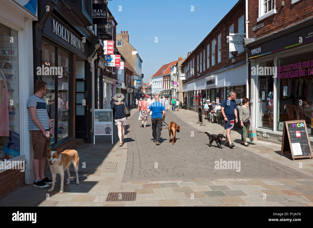 People shoppers visiting walking in the town centre in spring Beverley East Yorkshire England UK United Kingdom GB Great Britain Stock Photo