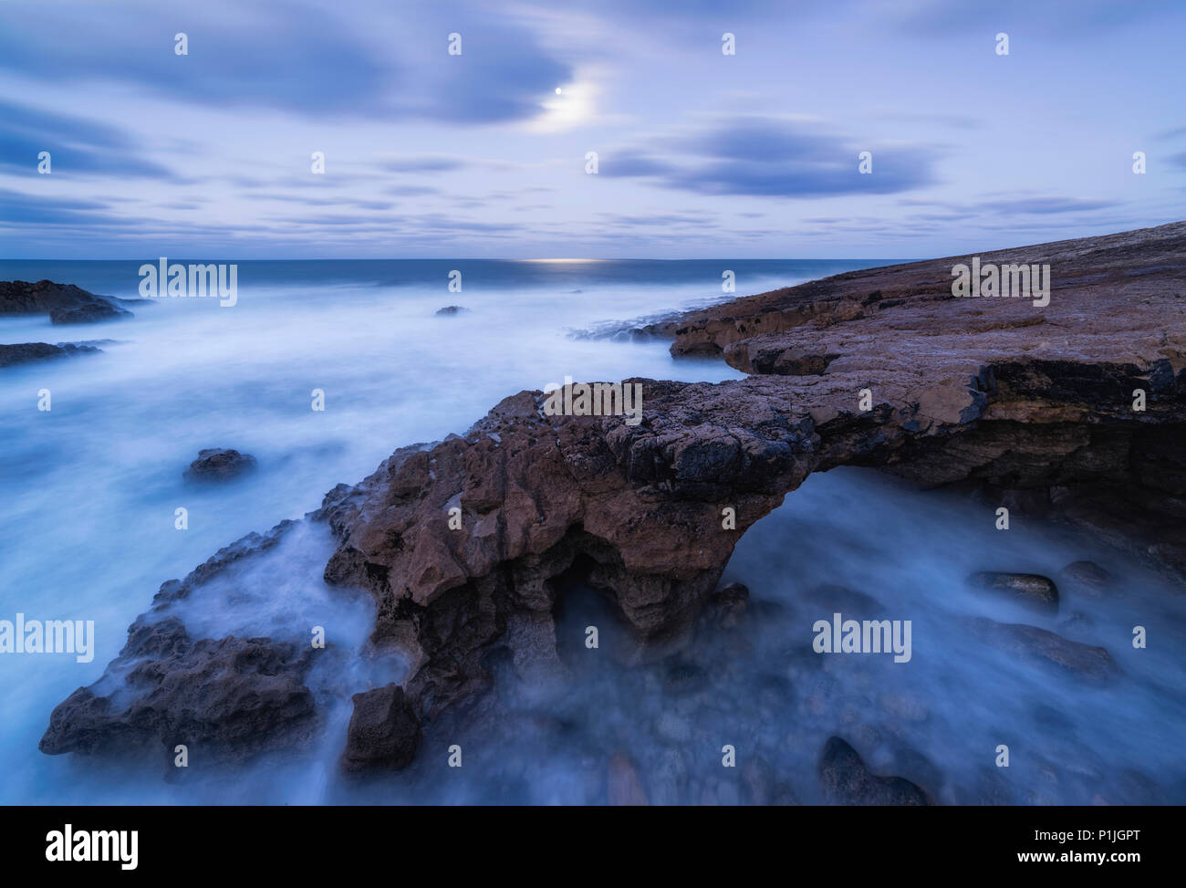 Storm on the stone coast with surf in the moonlight at dawn, Cabo Raso, Estoril, Lisbon, Portugal Stock Photo