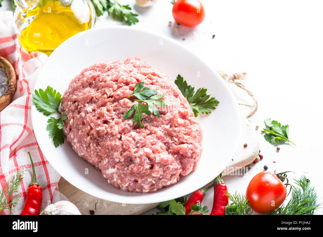 Minced meat with ingredients for cooking on white table. Stock Photo