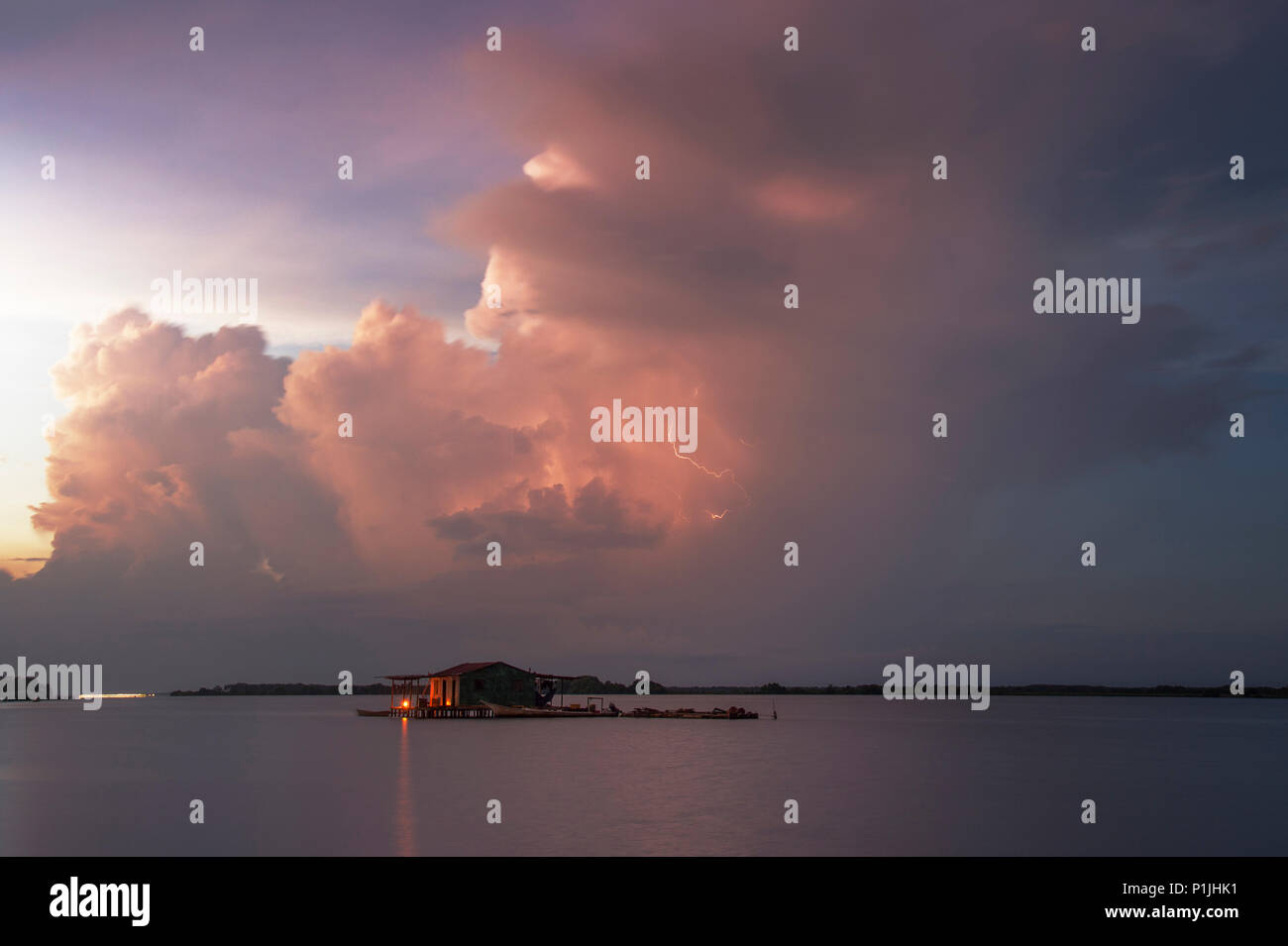 Multicell storm with staggered updrafts in the glowing light of the sunrise over lake Maracaibo (Catatumbo thunderstorm, the place with the highest lightning density worldwide), Ologa, Zulia, Venezuela, South America Stock Photo