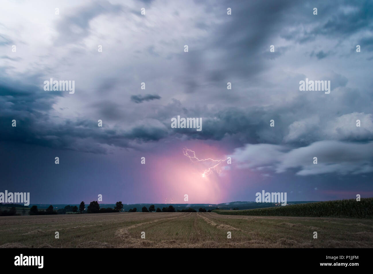 Lightning illuminated precipitation on the backside of a leaving supercell near Feuchtwangen, Baden-Wuerttemberg, Germany Stock Photo