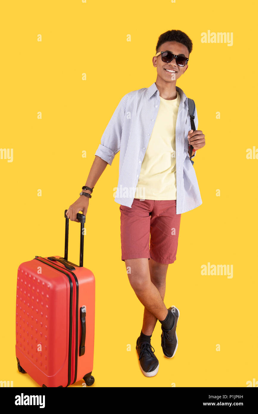 Cheerful happy man holding his luggage Stock Photo