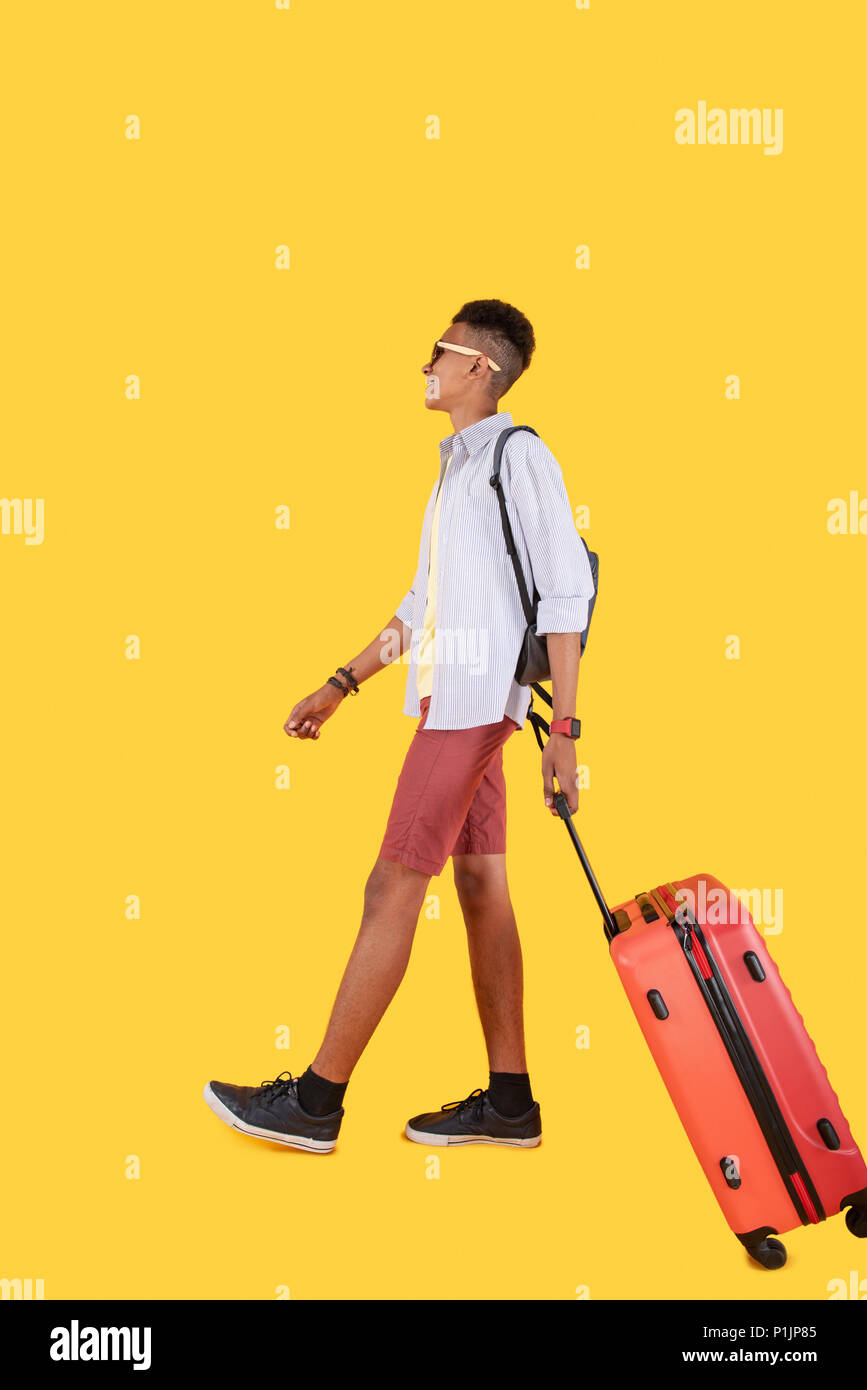 Happy nice man walking with a suitcase Stock Photo