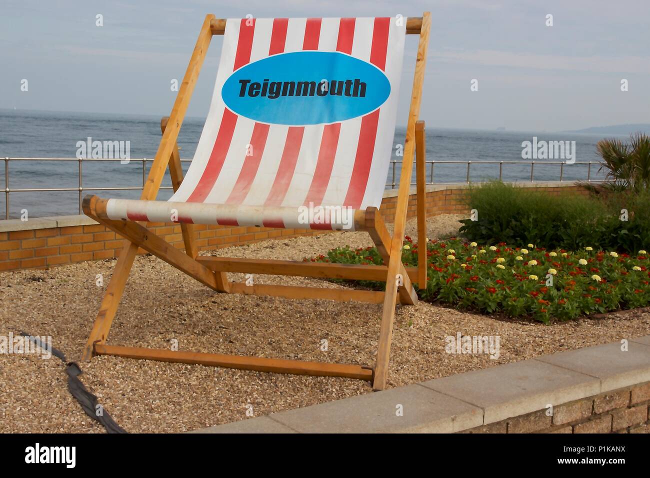A giant, striped, oversized deck chair on Teignmouth seafront, South Devon Stock Photo