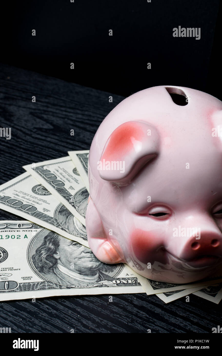 Pink piggy bank with dollar banknotes on black background Stock Photo ...
