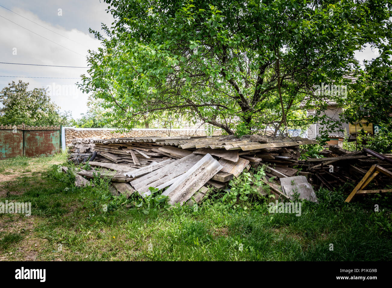 Old asbestos roof slates and boards. Dump of building materials Stock Photo