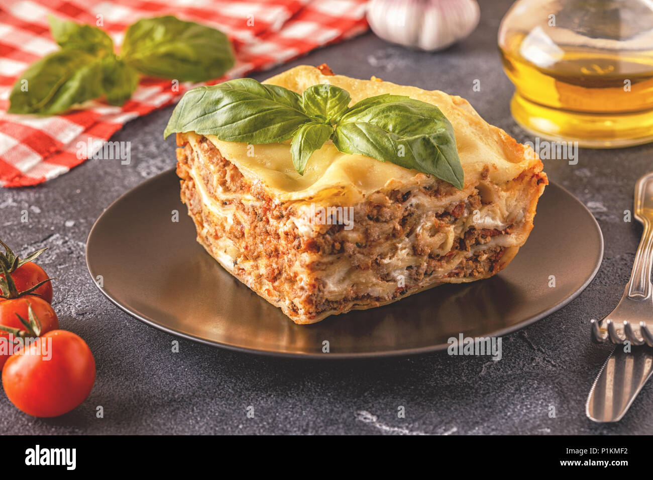 Traditional lasagna made with minced beef bolognese sauce and bechamel sauce topped with basil