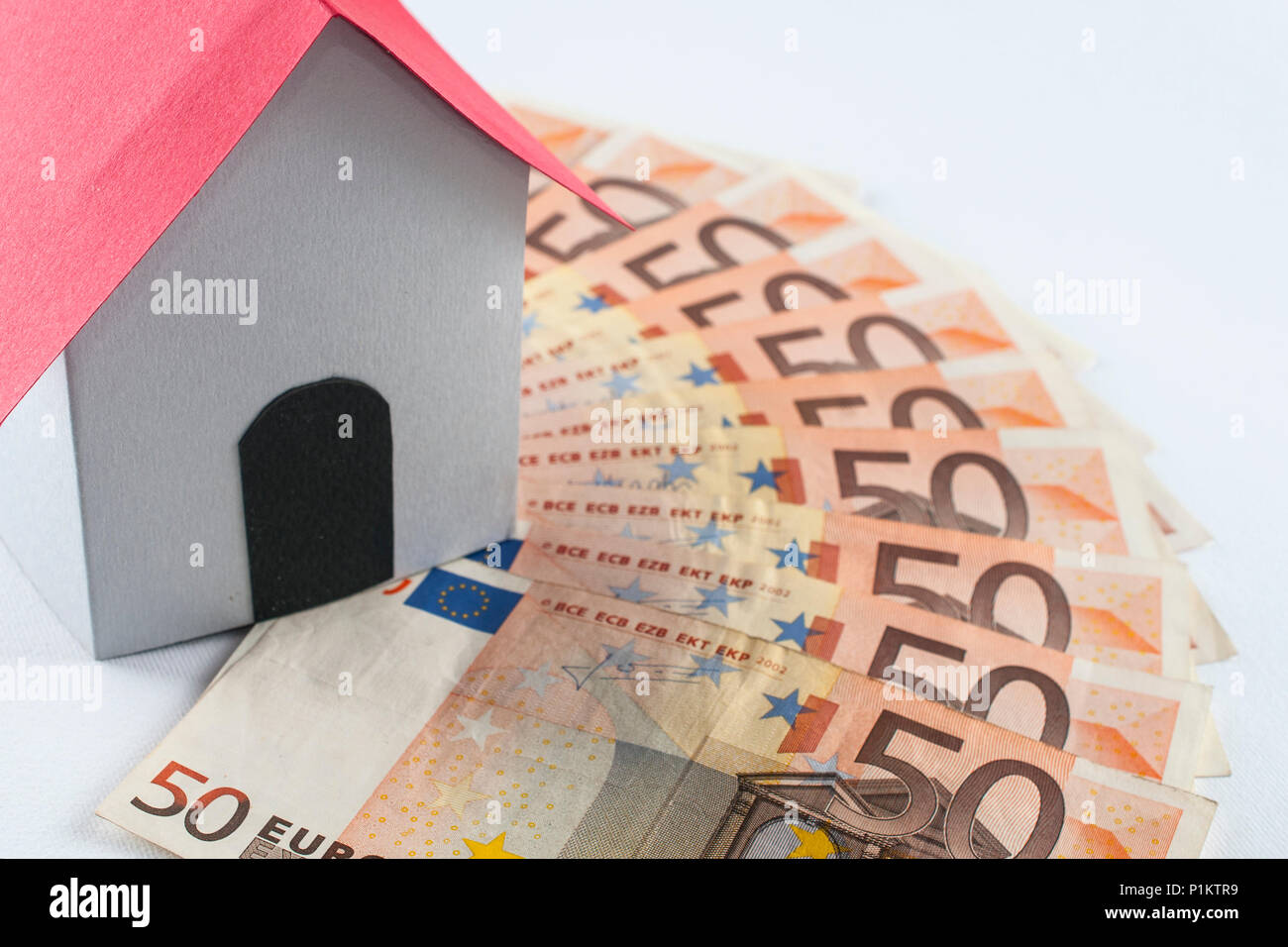 Mortgage and loan concept: paper house on a fifty euros banknote fan Stock Photo