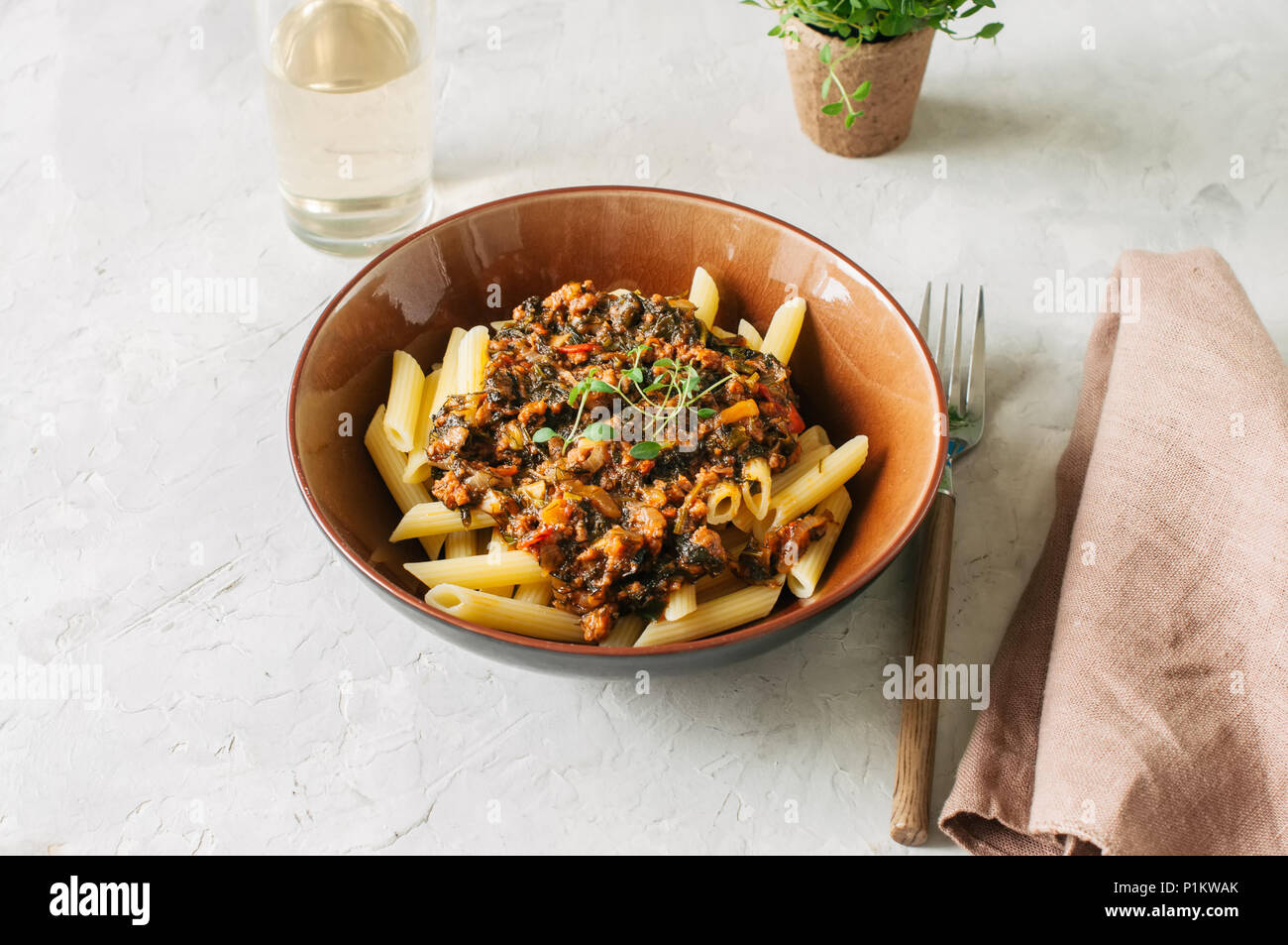 Tomato sauce ground beef pasta on a white stone background. Toned Stock