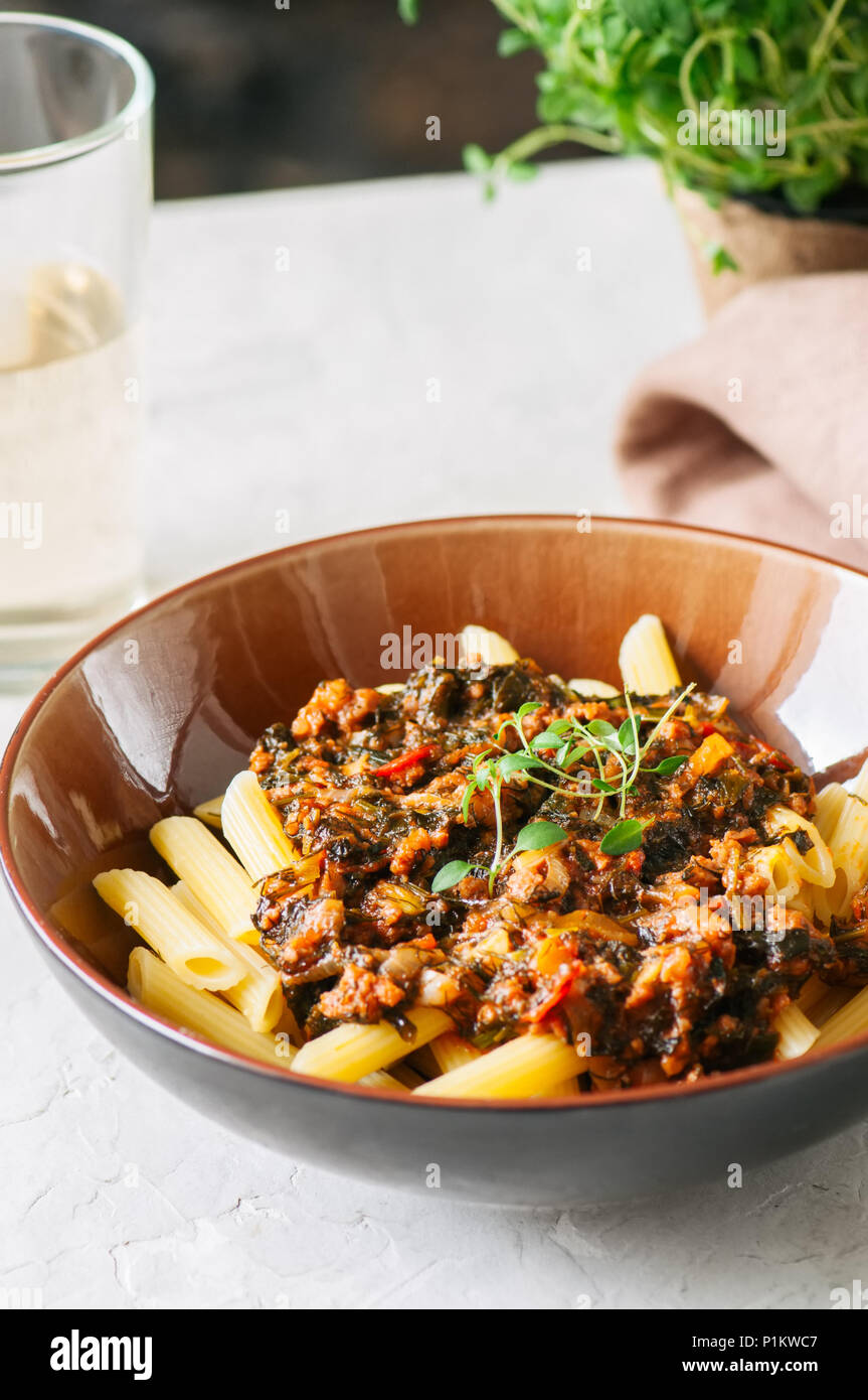 Tomato sauce ground beef pasta on a white stone background. Toned Stock