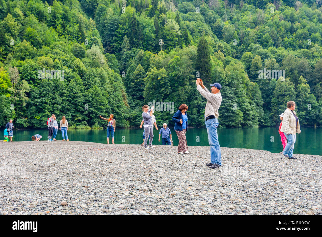Lake Ritsa, Abkhazia/Georgia - Aug 31, 2017: Group of people taking photos and selfies at scenic lake Ritsa Stock Photo