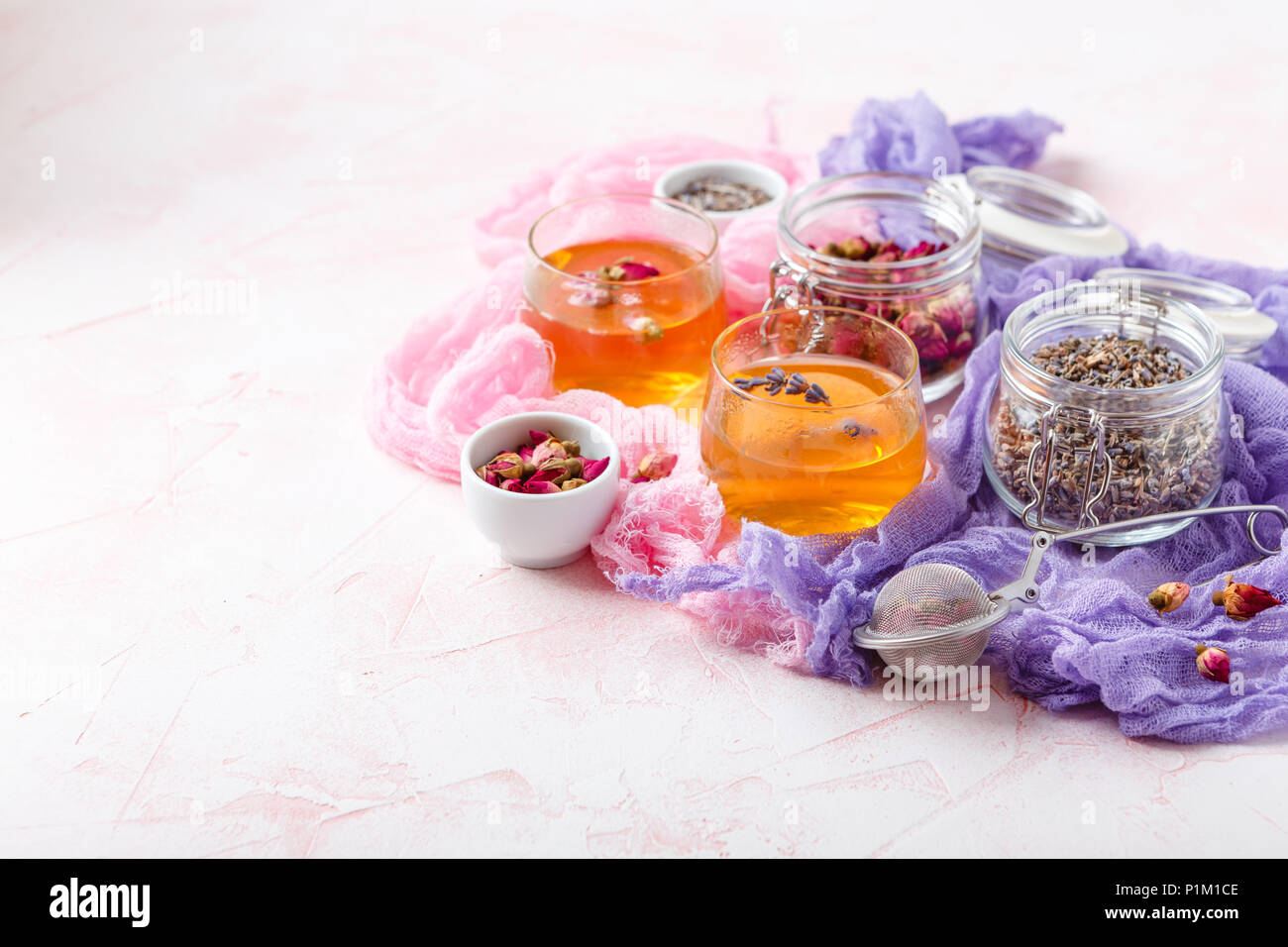 Herbal tea made from dried rose buds and lavender flowers in two transparent glass plates Stock Photo