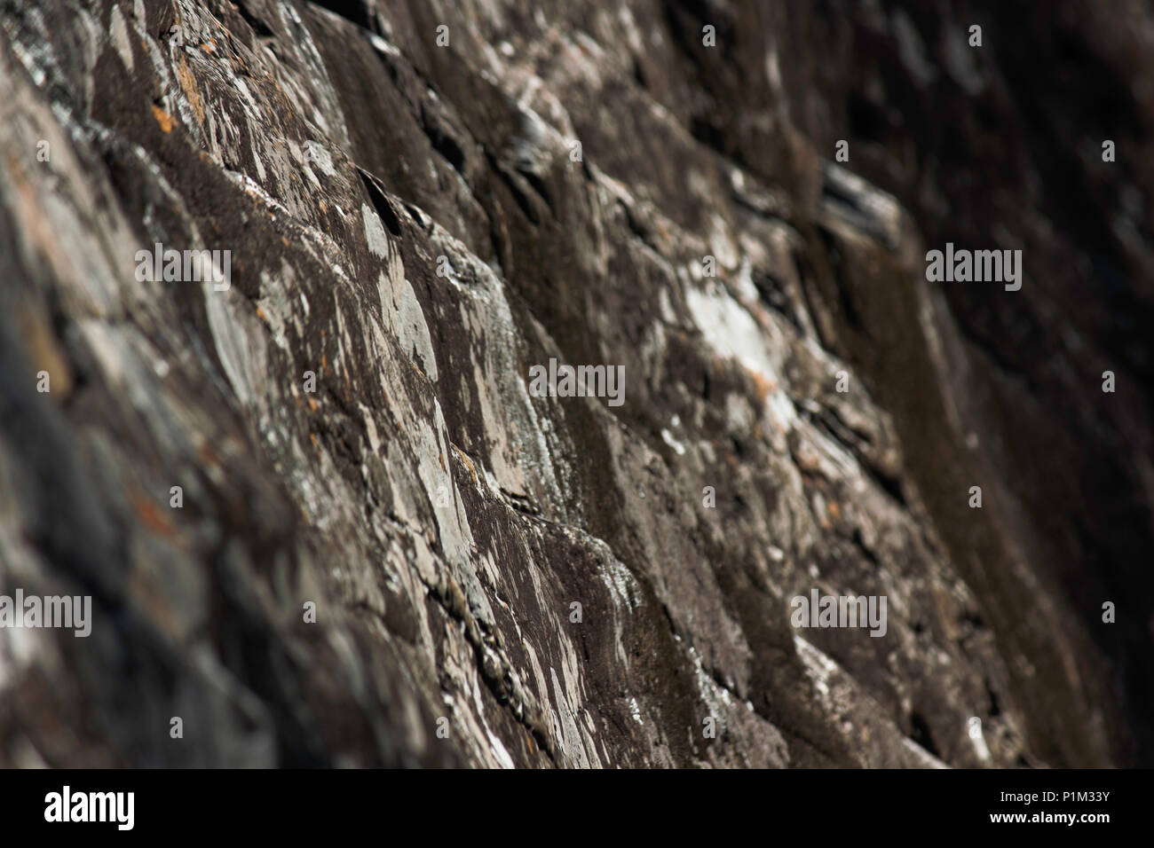 Natural Weathered Dark Stone Cliff Wall Stock Photo