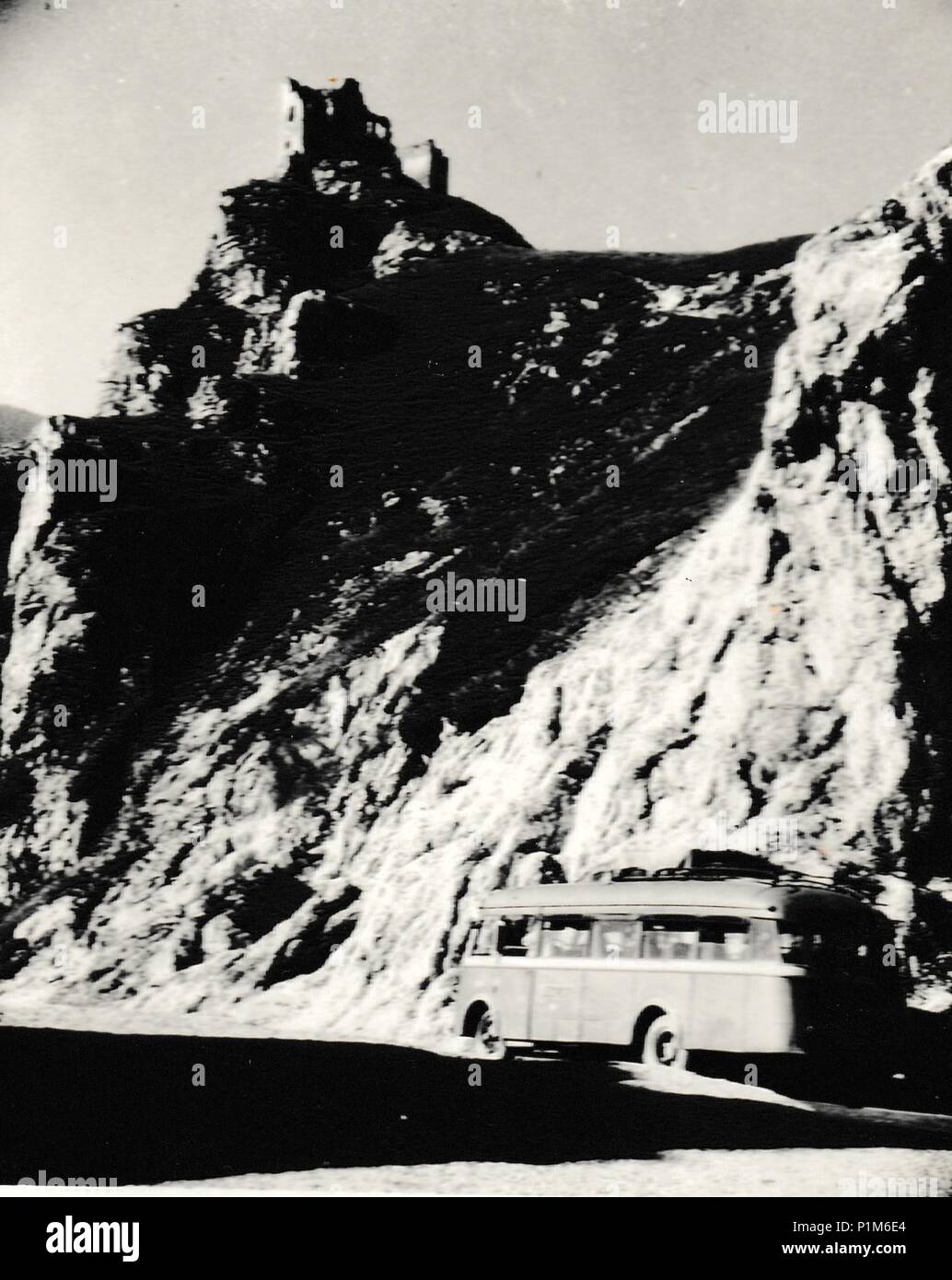 THE CZECHOSLOVAK SOCIALIST REPUBLIC - CIRCA 1950s: Retro photo shows a bus. The castle is on background. Vintage black & white photography. Stock Photo